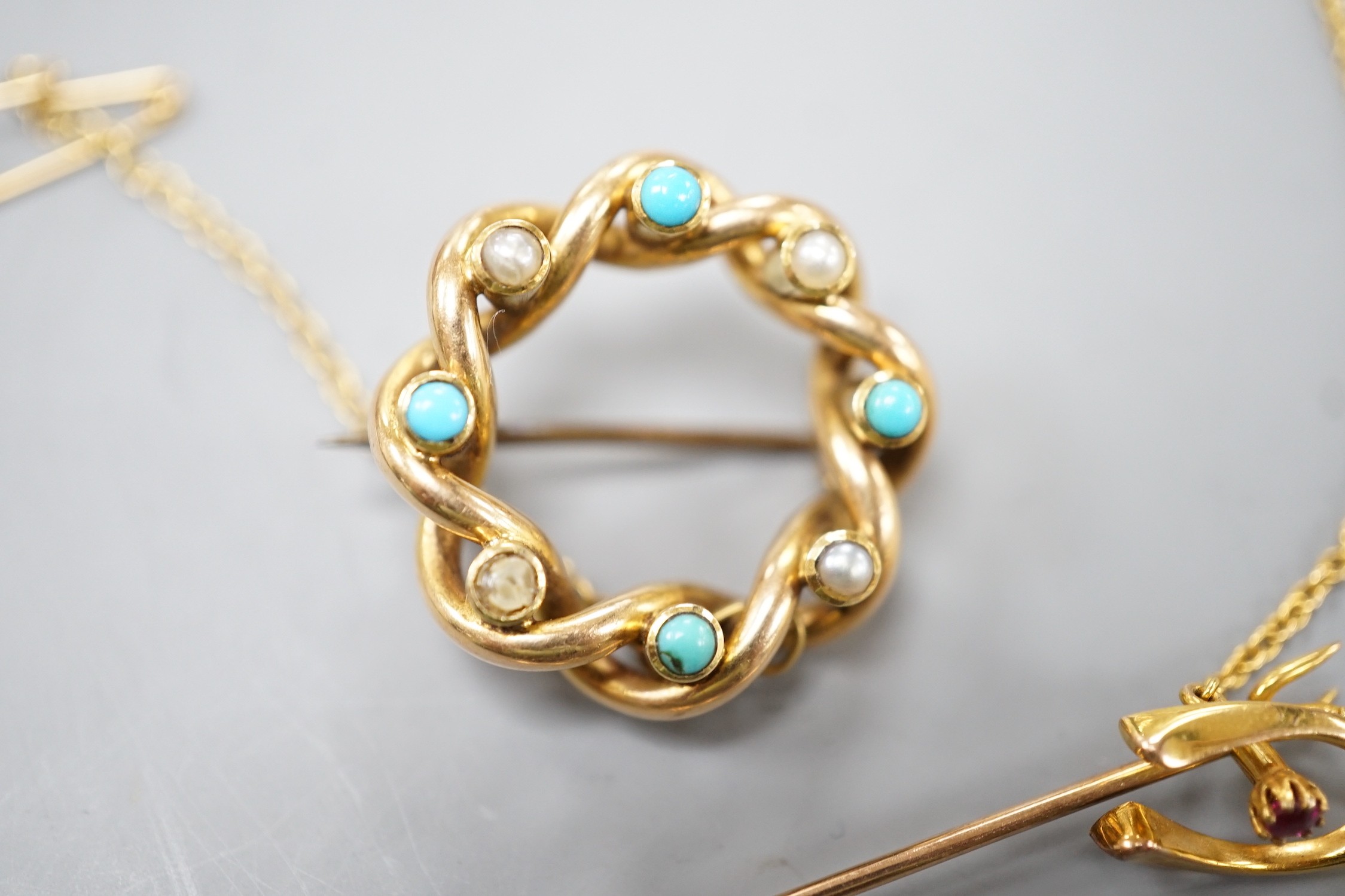 An Edwardian yellow metal, turquoise and split pearl set openwork brooch, 22mm, a similar coral and split pearl set ovoid brooch and a 15ct and gem set wish bone stick pin, gross weight 14.3 grams.